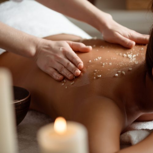 Young beautiful brunette girl relaxing in spa salon. Copy space.